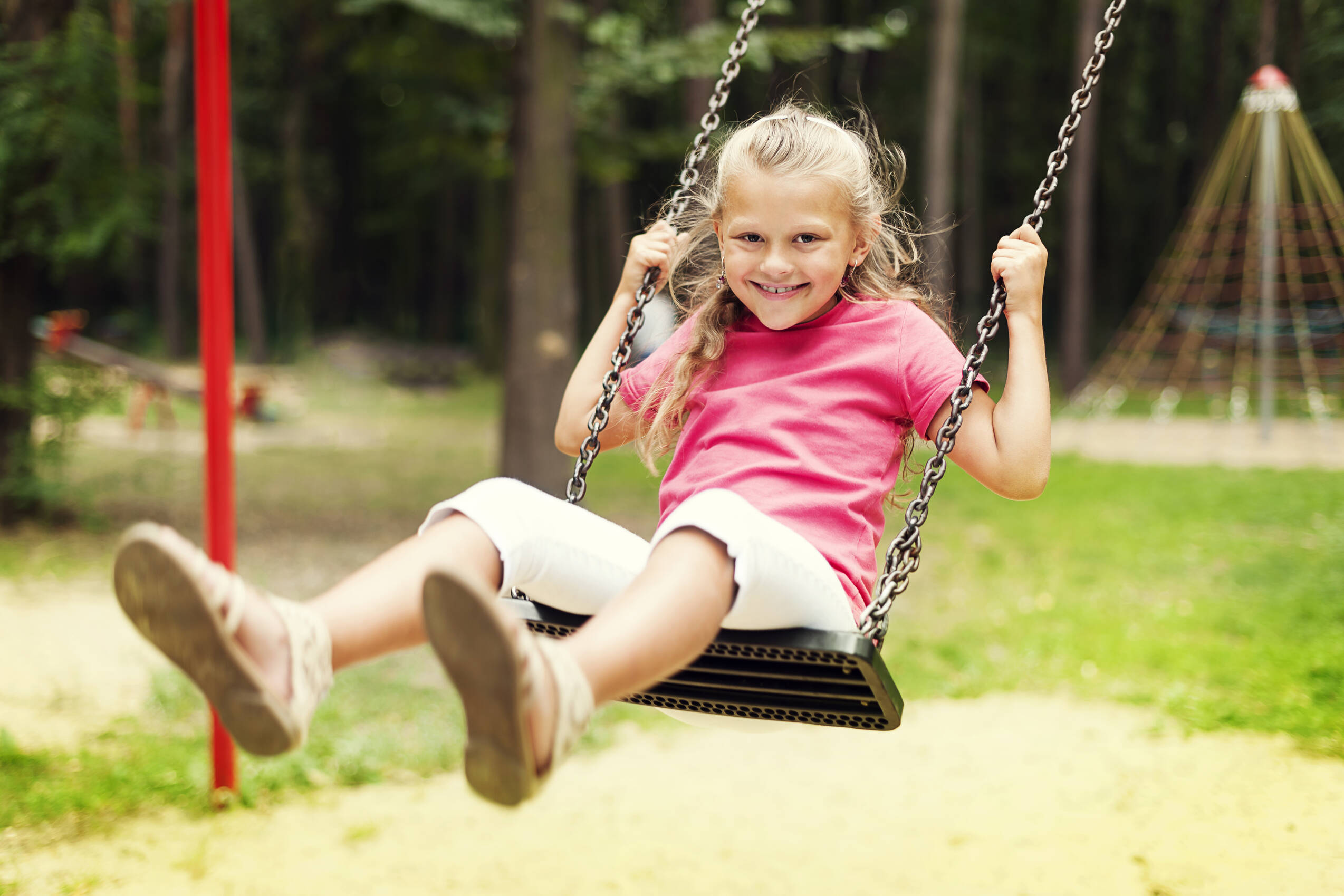 Happy girl swinging playground